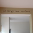 An Italian wall decal on the passageway ceiling beam - Chi mangia bene, vive bene