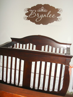 Brynlee wall decal above the wooden brown colored crib